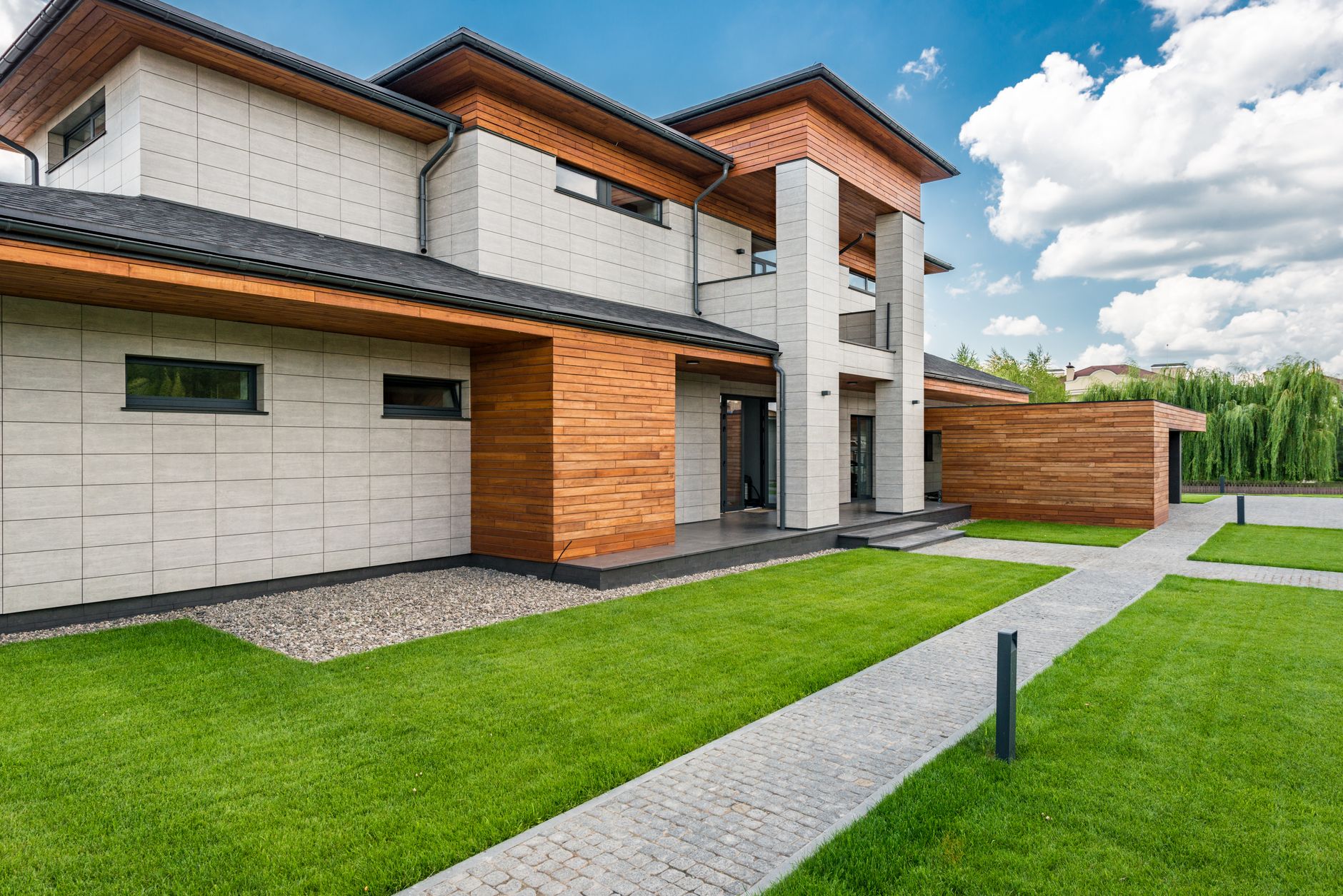 Beige standby generator installed beside a brick house on a concrete pad